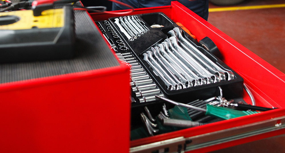 Professional toolbox with modern tools at garage. Mechanic taking facilities from special box for mechanical instruments