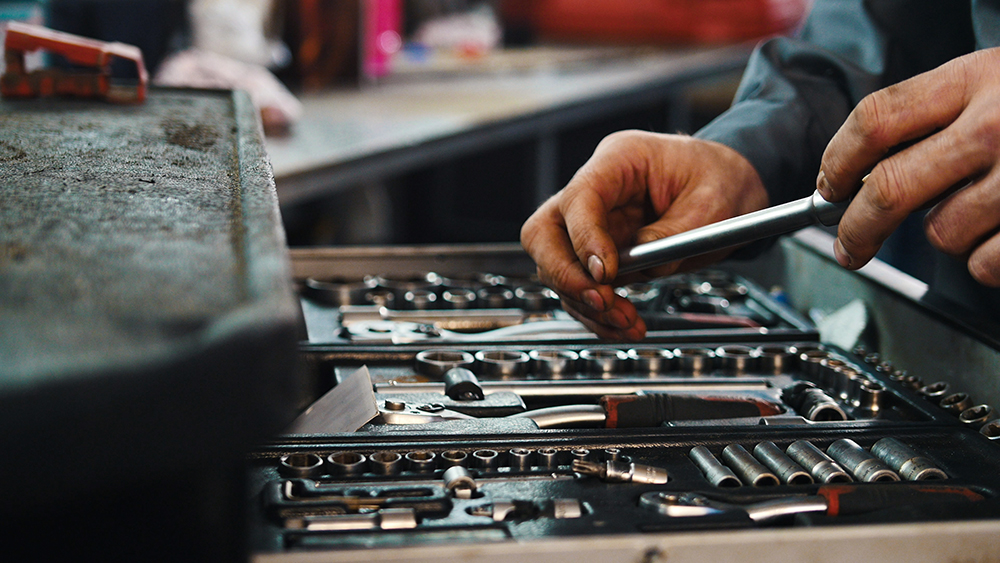 A set of tools for repair in car service - mechanic's hands, close up