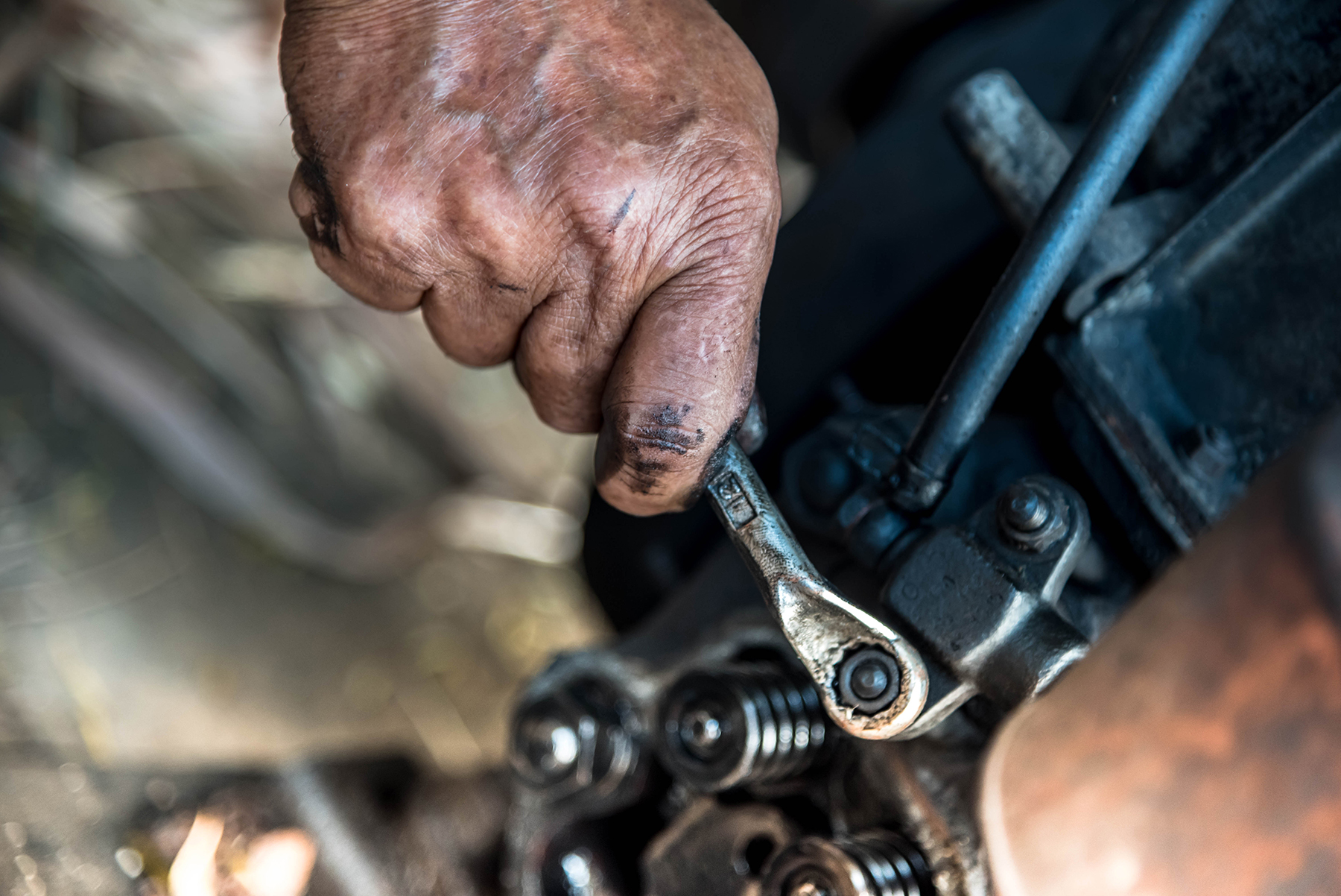 Hands repairing a engine with a wrench